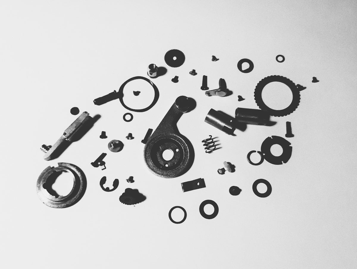 Assortment of mechanical parts scattered on a white background.